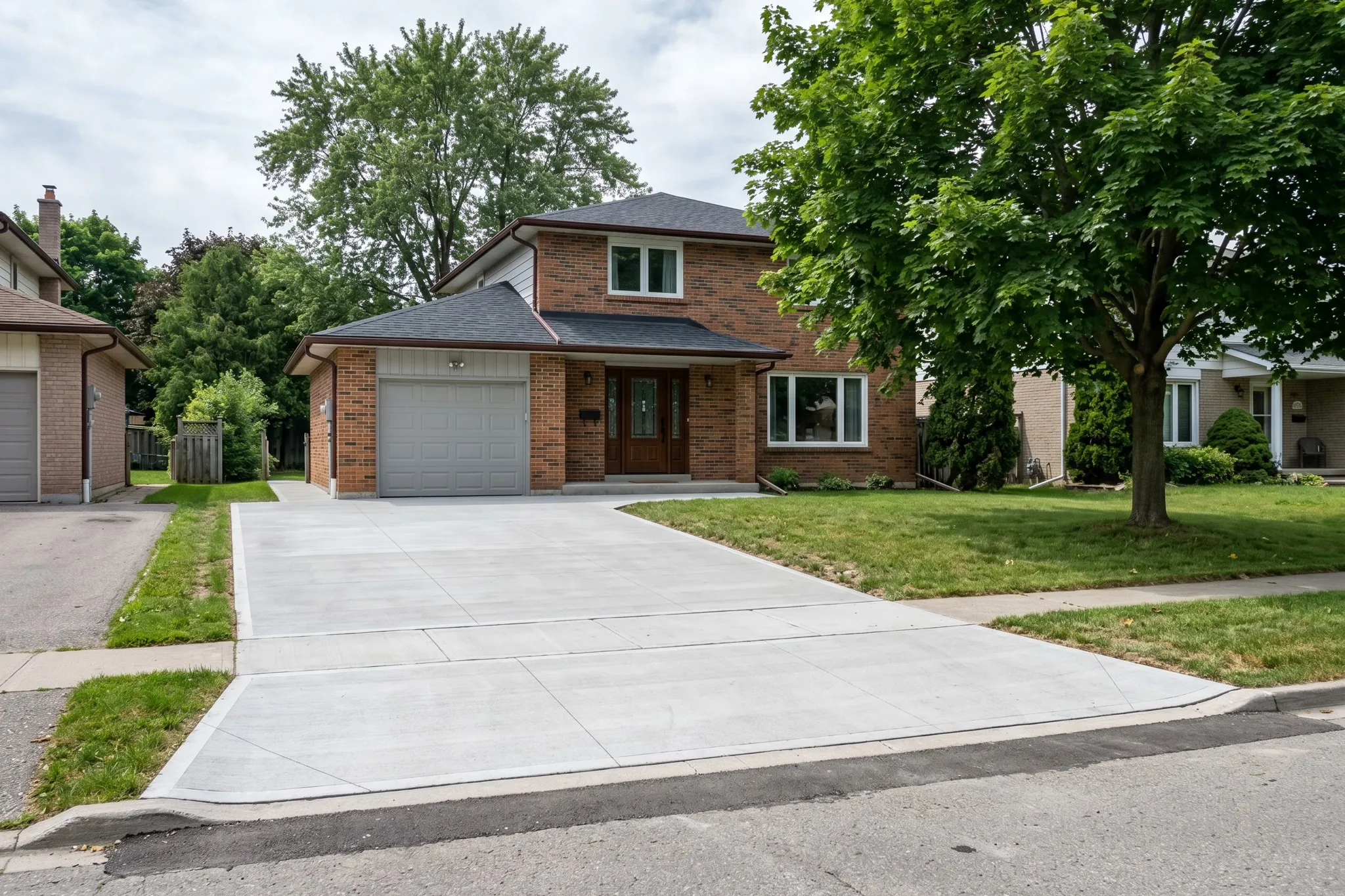 A finished concrete driveway at a two-storey brick home, Southern Ontario